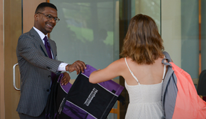 Assistant Dean Williams handing student a bag