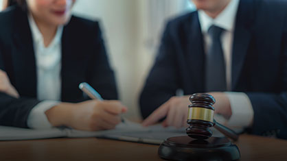 lawyers in background of gavel at desk