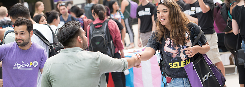 Graduate student organization leader shaking hands with student